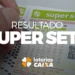 Mão preenchendo cartão da loteria Super Sete da Caixa com números marcados