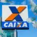 Logo da CAIXA com notas de R$ 100 flutuando ao redor, representando o saque de R$ 6,2 mil para CPFs com finais de 0 a 9 a partir de 30/01.