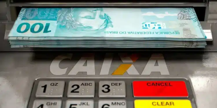 Caixa eletrônico da Caixa com cédulas de real, representando o pagamento do ressarcimento das cotas PIS/Pasep para quem solicitar o benefício até 31 de julho.