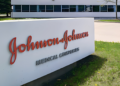 Placa com o logotipo da Johnson & Johnson em frente ao prédio corporativo