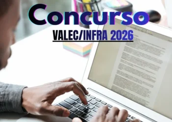 Pessoa digitando em um laptop com informações sobre o concurso VALEC INFRA 2026.