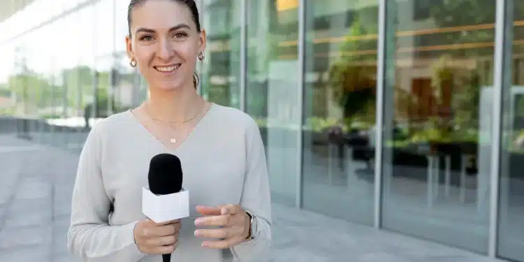Jornalista sorrindo com microfone, demonstrando confiança para seguir a carreira de repórter.