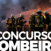 Grupo de bombeiros com equipamentos apaga incêndio intenso usando mangueiras de água