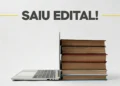 Imagem de laptop ao lado de uma pilha de livros, com destaque para o anúncio 'SAIU EDITAL!' para concurso público da Prefeitura.