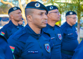 Guardas municipais uniformizados perfilados em evento ao ar livre durante o dia