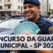 Guarda Municipal sorrindo mostra várias notas de R$ 100 em frente a viatura em avenida movimentada