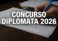 Mão preenchendo prova de concurso com caneta azul, sobre uma folha de teste, com texto 'Concurso Diplomata 2026' em destaque.