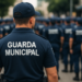 Agente da Guarda Municipal uniformizado observa fileira de colegas durante treinamento externo
