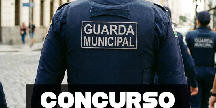 Guarda Municipal de costas em uniforme azul patrulhando rua com outros agentes ao fundo