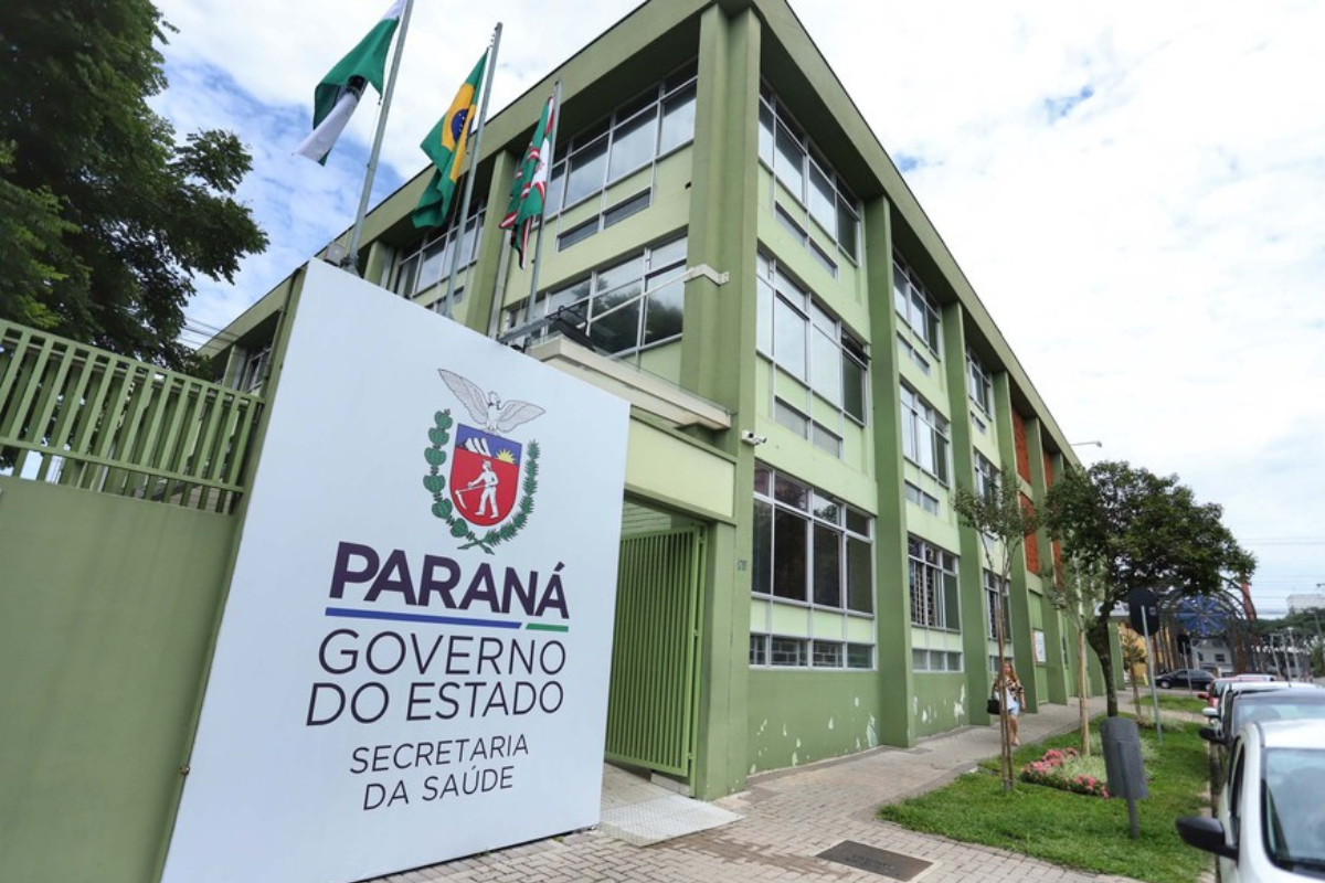 Concurso SESA PR Prédio verde da Secretaria da Saúde do Paraná com placa institucional e bandeiras hasteadas