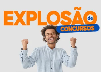 Jovem sorridente levanta os punhos em gesto de vitória diante de letreiro sobre concursos