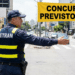 Agente do Detran faz sinalização em rua movimentada com faixa de concursos previstos 2026