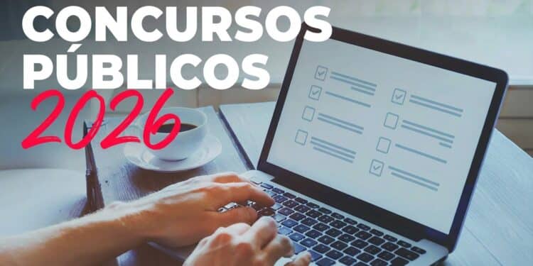 Mãos digitando em notebook com tela de simulado de prova; xícara de café ao lado