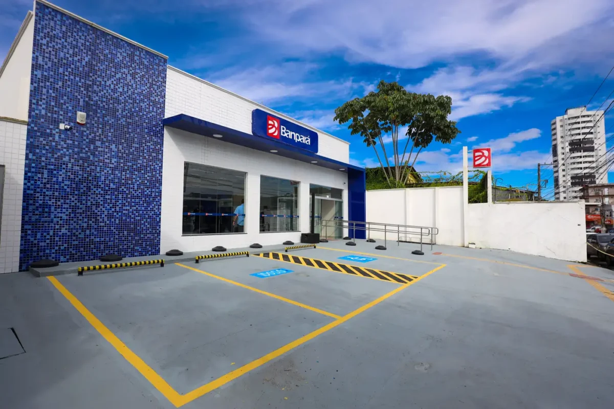 Concurso Banpará Agência Banpará com estacionamento sinalizado e fachada azul sob céu aberto