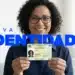 uma mulher sorrindo e segurando sua nova Carteira de Identidade brasileira, que traz melhorias no design e segurança.