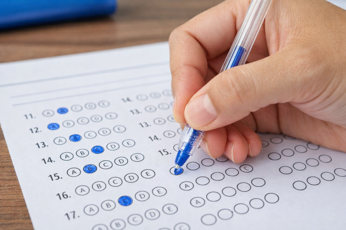 Editais abertos Pessoa marcando respostas em cartão de prova de múltipla escolha com caneta azul