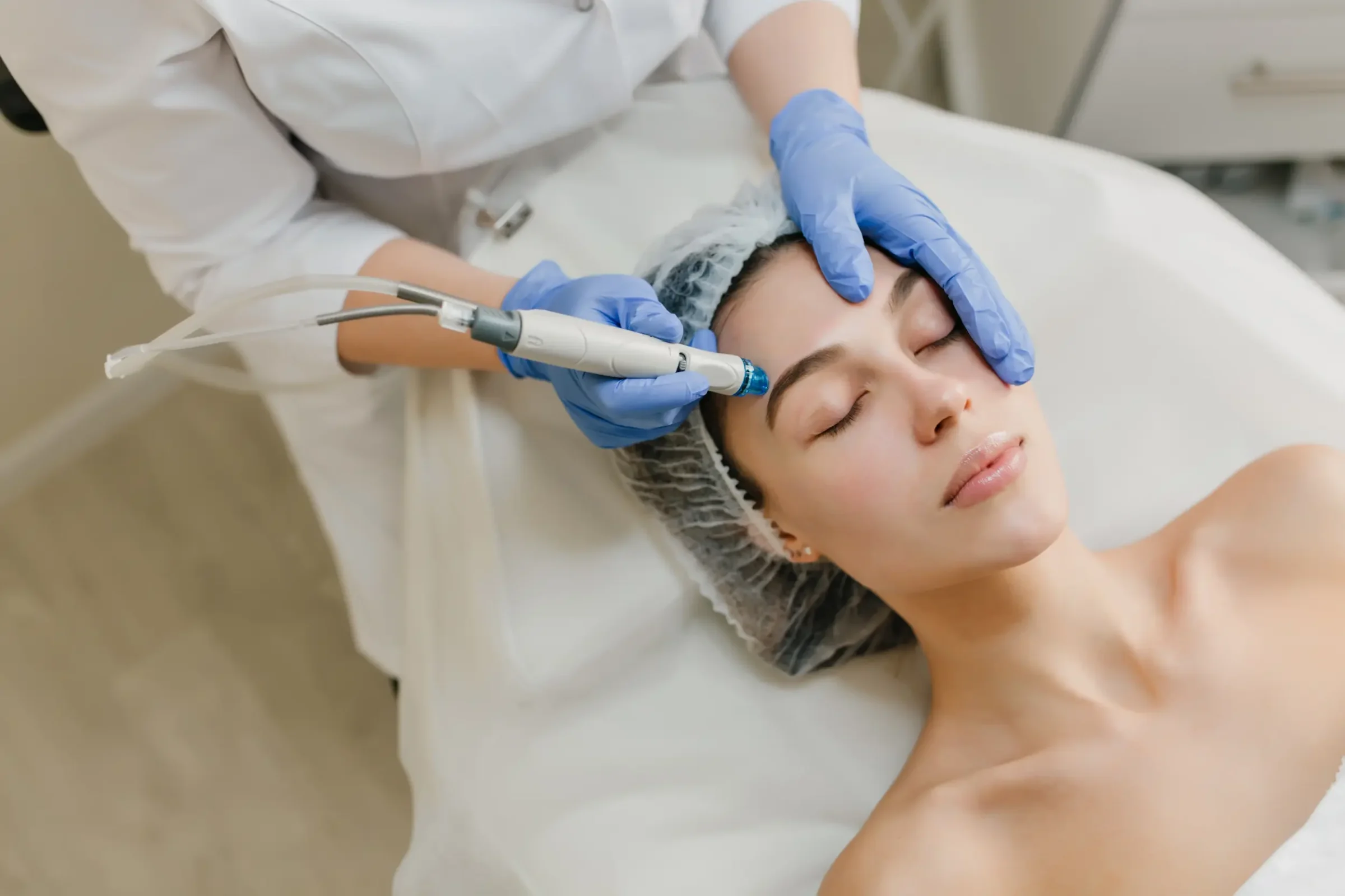 Estética Profissional de estética aplicando um tratamento facial em uma cliente, com equipamentos modernos e cuidados de beleza.
