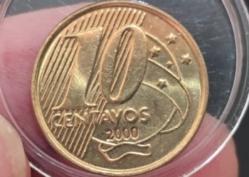Close de uma moeda de 10 centavos de Real do ano 2000, protegida por uma cápsula de acrílico transparente, mostrando o número 10 e o ano de cunhagem com clareza.