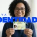 Mulher sorrindo enquanto segura sua nova carteira de identidade do Brasil, destacando o novo design.