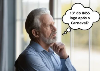 Homem idoso pensativo olhando pela janela sobre pagamento da primeira parcela do 13º salário do INSS após o Carnaval