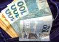 Notas de R$ 100,00, representando a liberação de R$ 1.200 do programa Pé-de-Meia pelo governo.