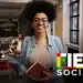 Jovem estudante sorridente segura um livro, representando a complementação de dados do Fies 2026, com prazo até terça-feira, 24 de fevereiro.