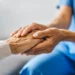 Médico segurando as mãos de um paciente idoso em um gesto de apoio e cuidado, ilustrando a importância de profissões estáveis como a medicina no Brasil.