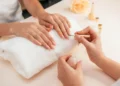 Profissional realiza serviço de manicure durante atendimento em salão de estética.