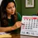 Mulher brasileira consultando calendário de setembro de 2026 em mesa de escritório, representando o planejamento do calendário completo de folgas.