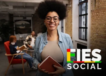 Pessoa sorridente em um ambiente moderno de estudo, representando o lançamento dos resultados do FIES 2026.1.