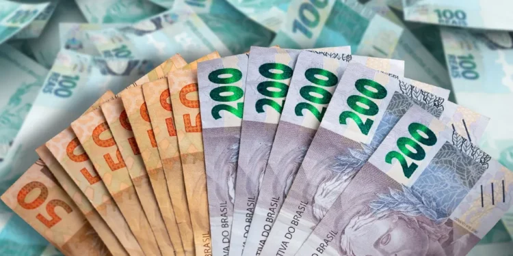 Notas de real espalhadas e valores de R$ 50 e R$ 200 representando saque de R$ 6.220 liberado pela CAIXA para brasileiros até 17/02.
