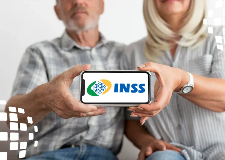 Aplicativo do INSS. Casal de idosos segura celular exibindo logotipo do INSS juntos.