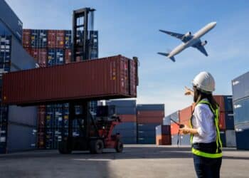 Porto de carga com containers e avião, representando a logística de importação e exportação de mercadorias no Brasil.