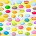 Ilusão de ótica com diversos ovos de Páscoa com cores e padrões variados espalhados em fundo ondulado colorido