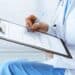 Médica preenchendo um formulário médico durante atendimento da perícia médica.