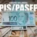 Notas de 100 reais brasileiras com o logo do Abono Salarial PIS/Pasep, representando a liberação do benefício em março.
