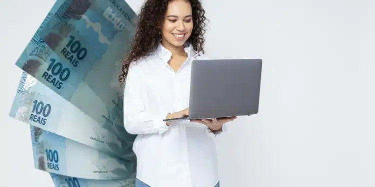 Profissional trabalhando no computador com dinheiro ao fundo, representando o crescimento salarial nas profissões de 2026.
