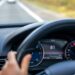 Motorista conduz veículo em rodovia com velocímetro indicando alta velocidade, ilustrando riscos associados ao aumento da velocidade no trânsito.