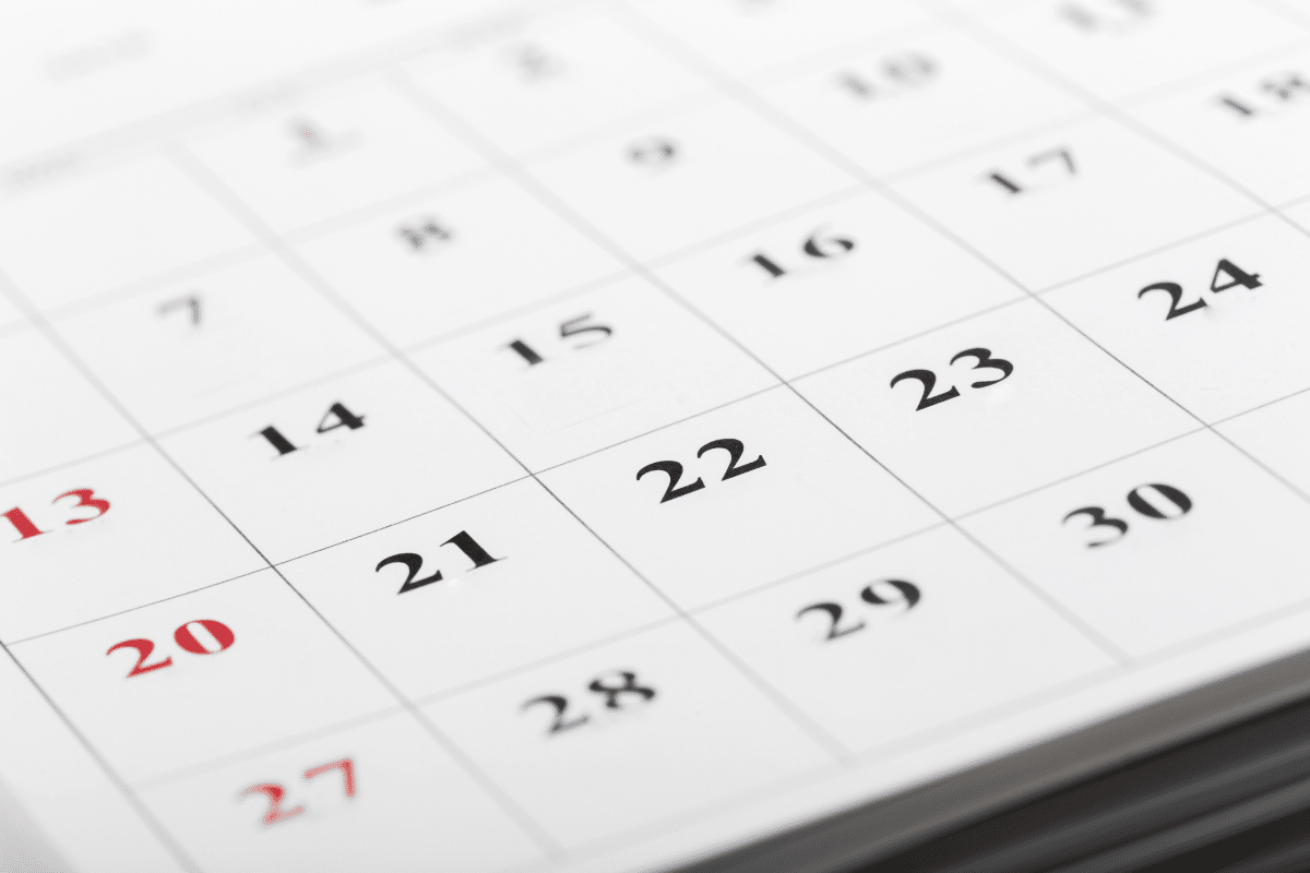 Folha de calendário com datas em destaque em preto e vermelho
