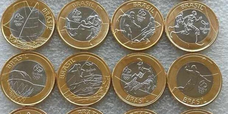 Coleção completa com 16 moedas de 1 Real comemorativas dos Jogos Olímpicos Rio 2016, exibindo diferentes modalidades esportivas e os mascotes Tom e Vinícius sobre um fundo cinza.