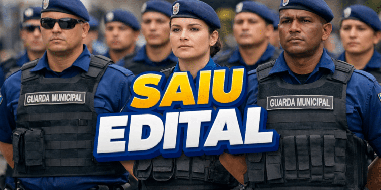 Grupo de guardas municipais em formação usando uniformes azuis e coletes, destaque para faixa "SAIU EDITAL"