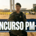 Policial militar fardada em posição de destaque com Congresso Nacional ao fundo ao entardecer