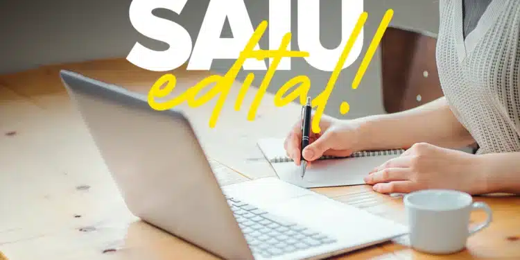 Mulher escrevendo em caderno ao lado de notebook com texto Saiu Edital representando abertura das inscrições do concurso da Prefeitura
