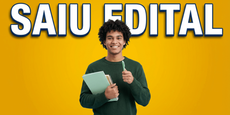 Estudante sorridente segura cadernos e caneta com gesto positivo diante de fundo amarelo