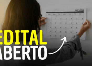 Pessoa prende calendário de outubro na parede com destaque para datas