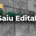 Letreiro da Petrobras em parede cinza com aviso em destaque "Saiu Edital!" em branco