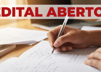 Mão segurando caneta enquanto escreve em caderno durante preparação