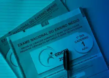 Caderno de questões do Exame Nacional do Ensino Médio 2026, com caderno azul, caneta e folha de papel em fundo azul, representando a preparação para o vestibular.