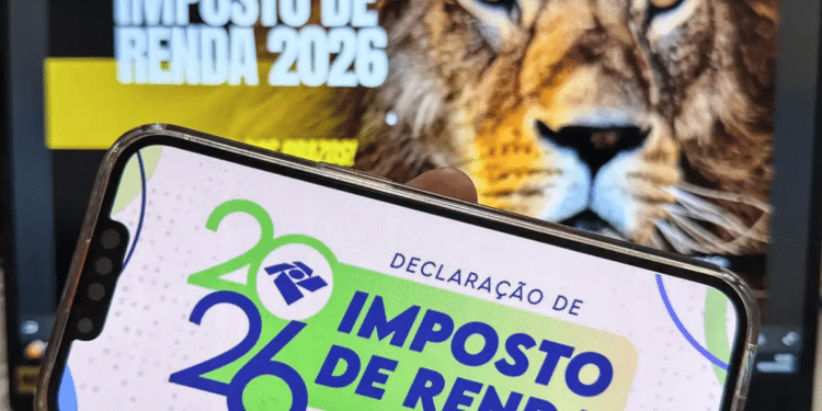 Celular com tela da Declaração de Imposto de Renda 2026 e leão ao fundo — documentos necessários para declarar o IR 2026