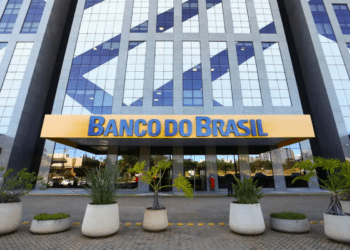 Prédio espelhado do Banco do Brasil com letreiro amarelo e plantas na entrada